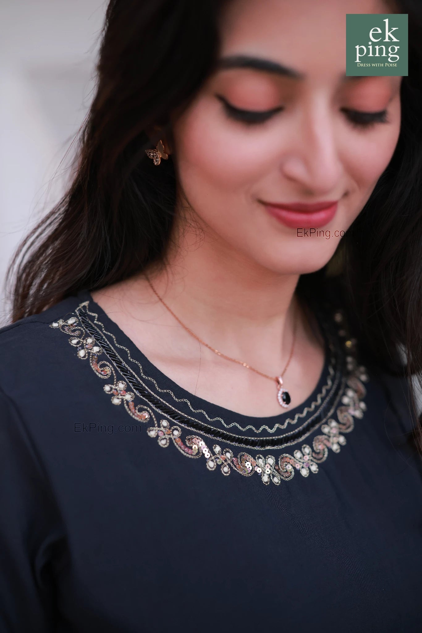 Woman wearing a black daily wear long kurti and salwar set with an intricate neckline design, close-up shot.