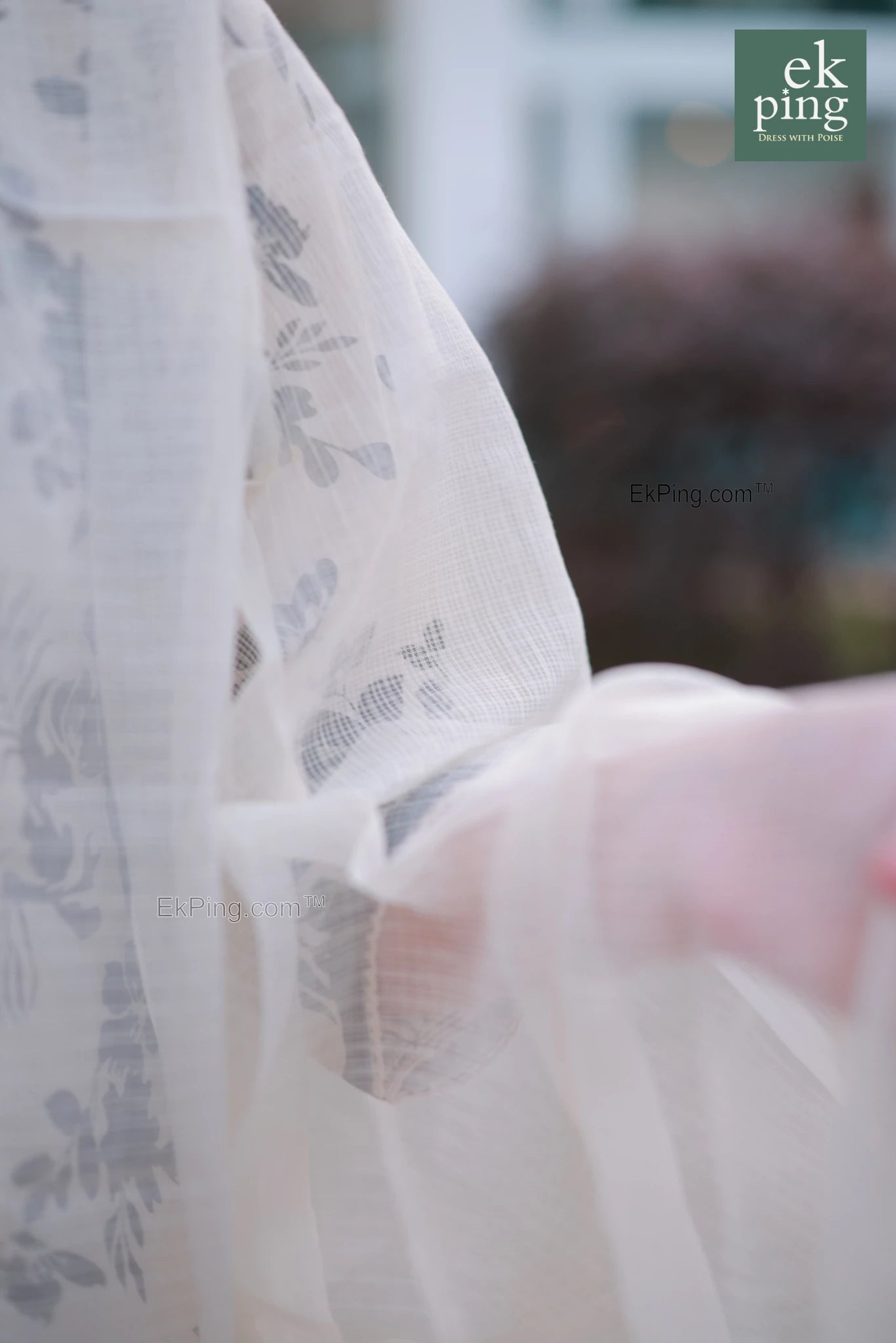 Close-up of a white supernet dupatta with floral patterns, blurred background
