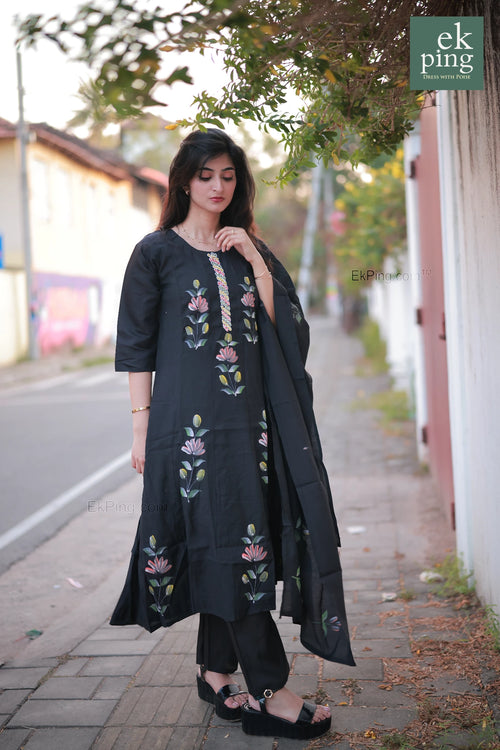 Woman wearing a black salwar set on a street with 'ek ping' branding.