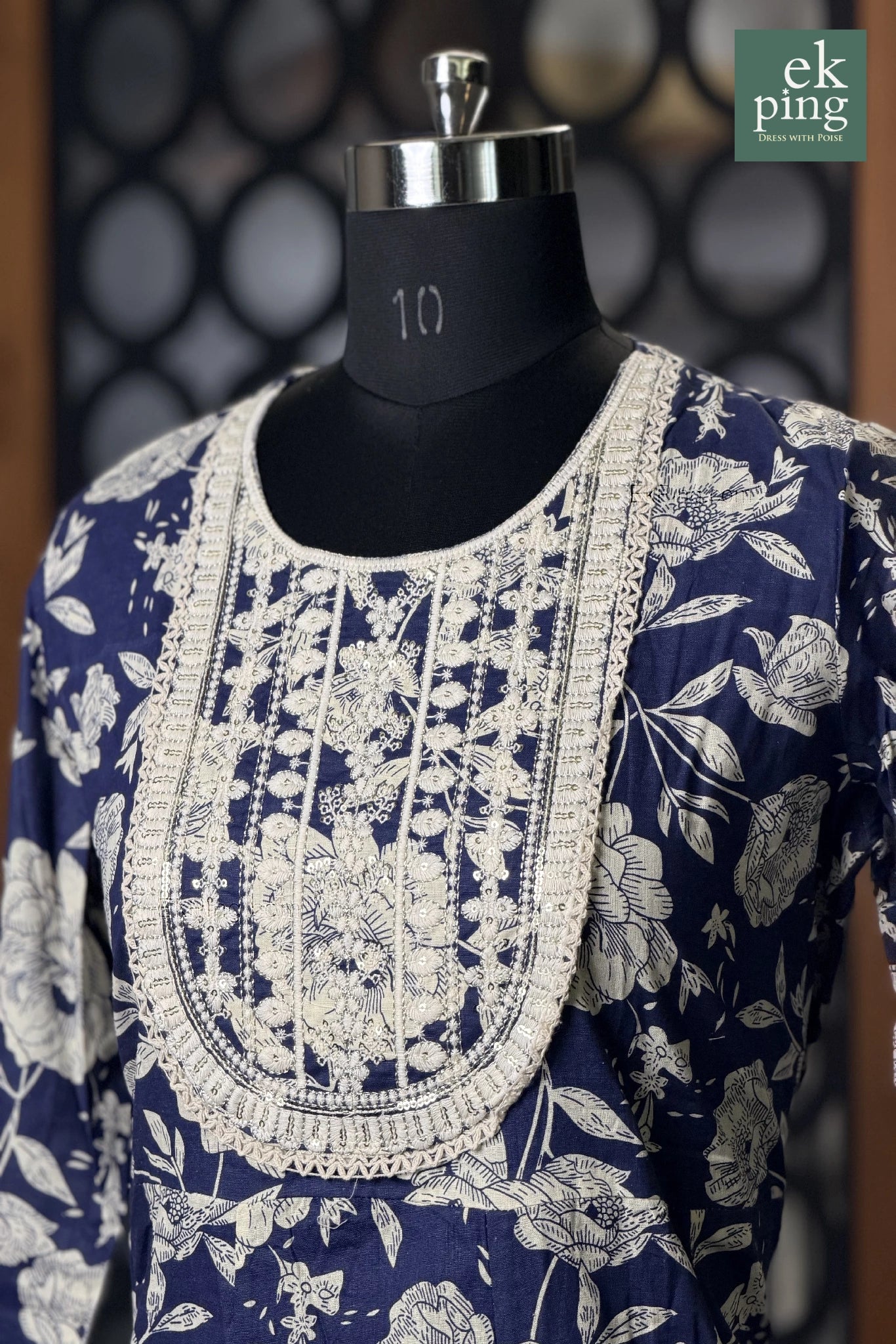 Navy blue and white floral anarkal dress with intricate embroidery on a mannequin against a blurred background.