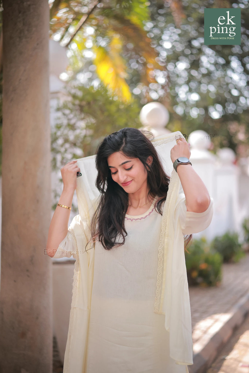 Woman in a light-colored traditional chanderi office wear kurti standing outdoors with greenery in the background
