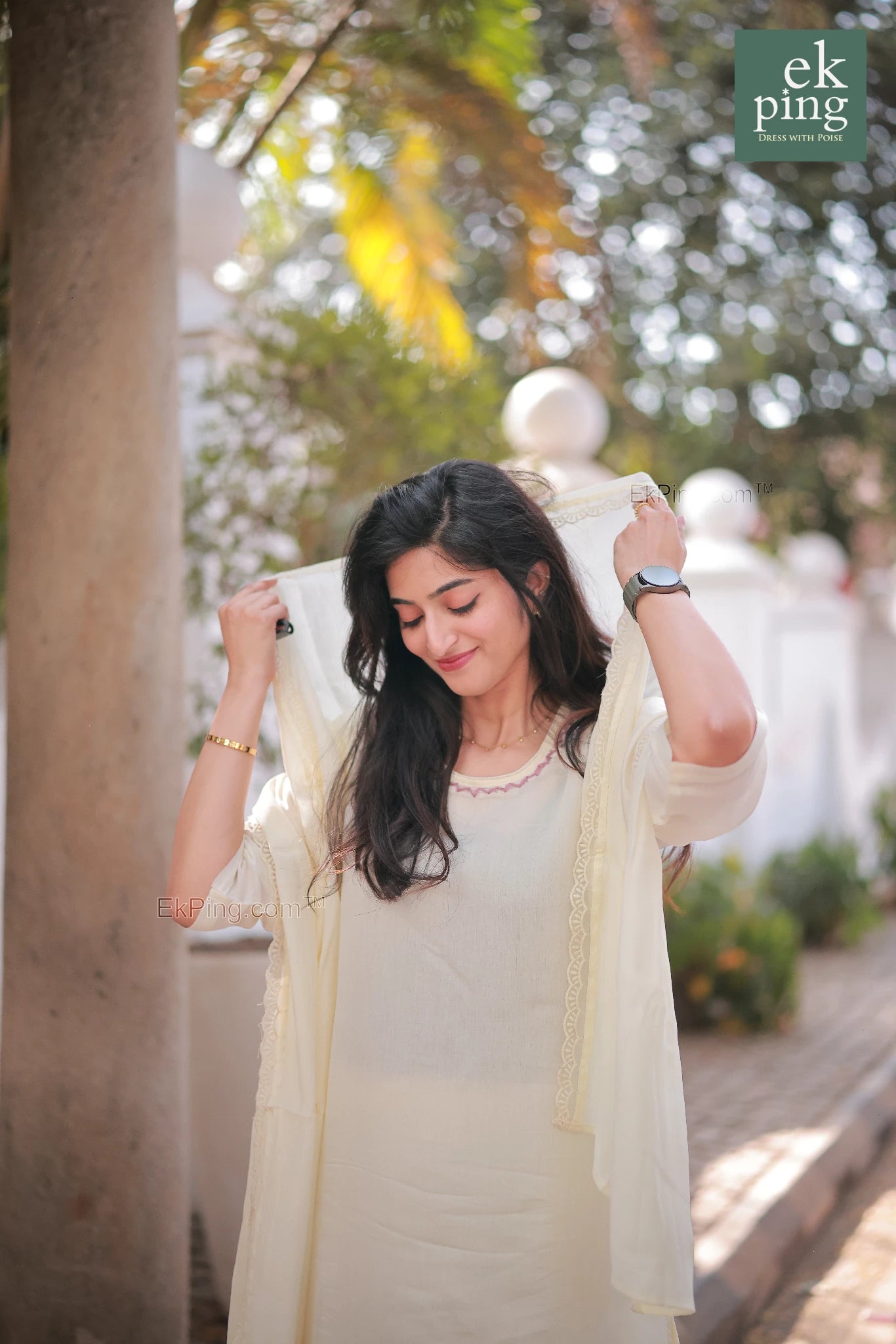 Woman in a light-colored traditional chanderi office wear kurti standing outdoors with greenery in the background