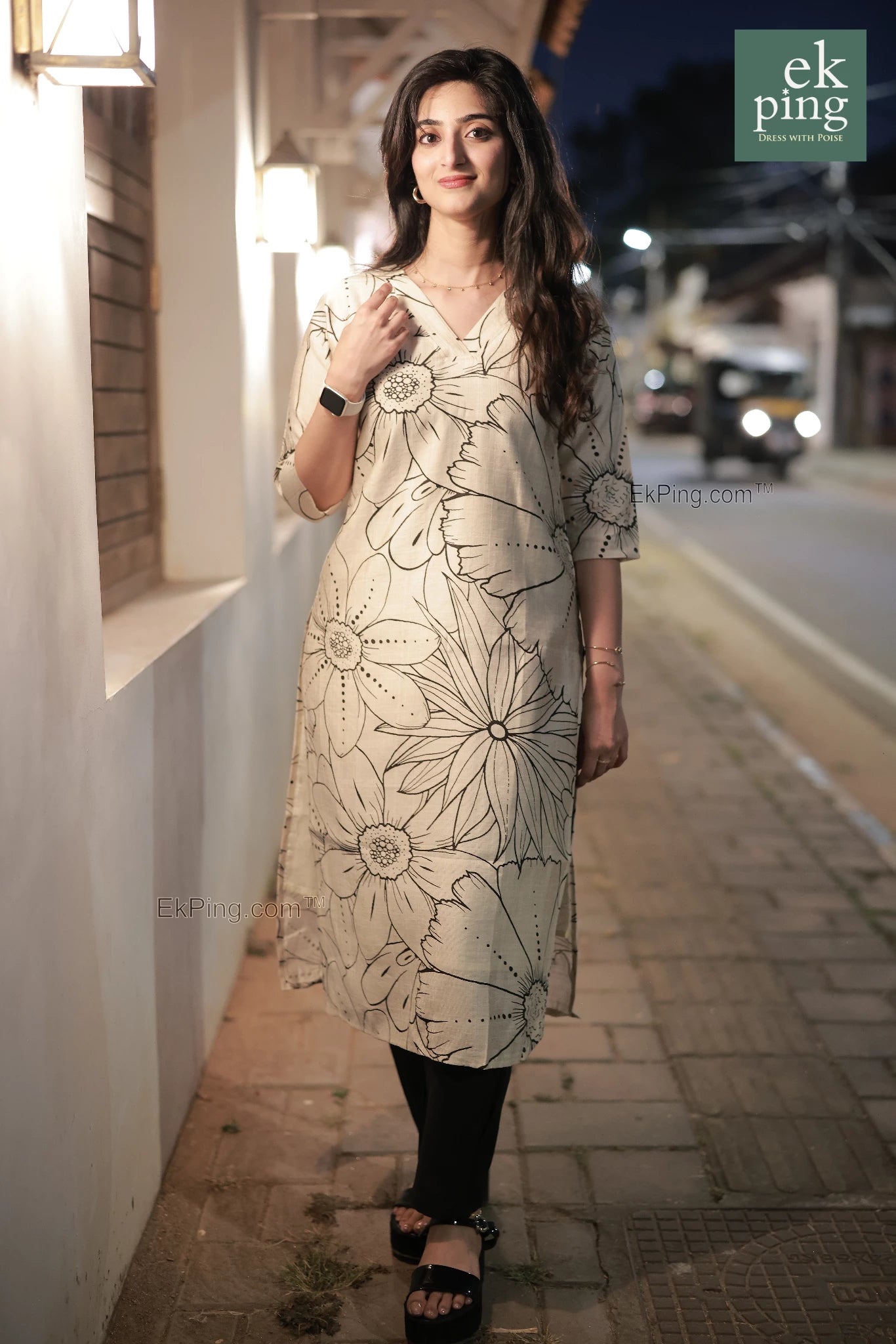 Girl in cream floral office wear kurti on street fort kochi with lights in background