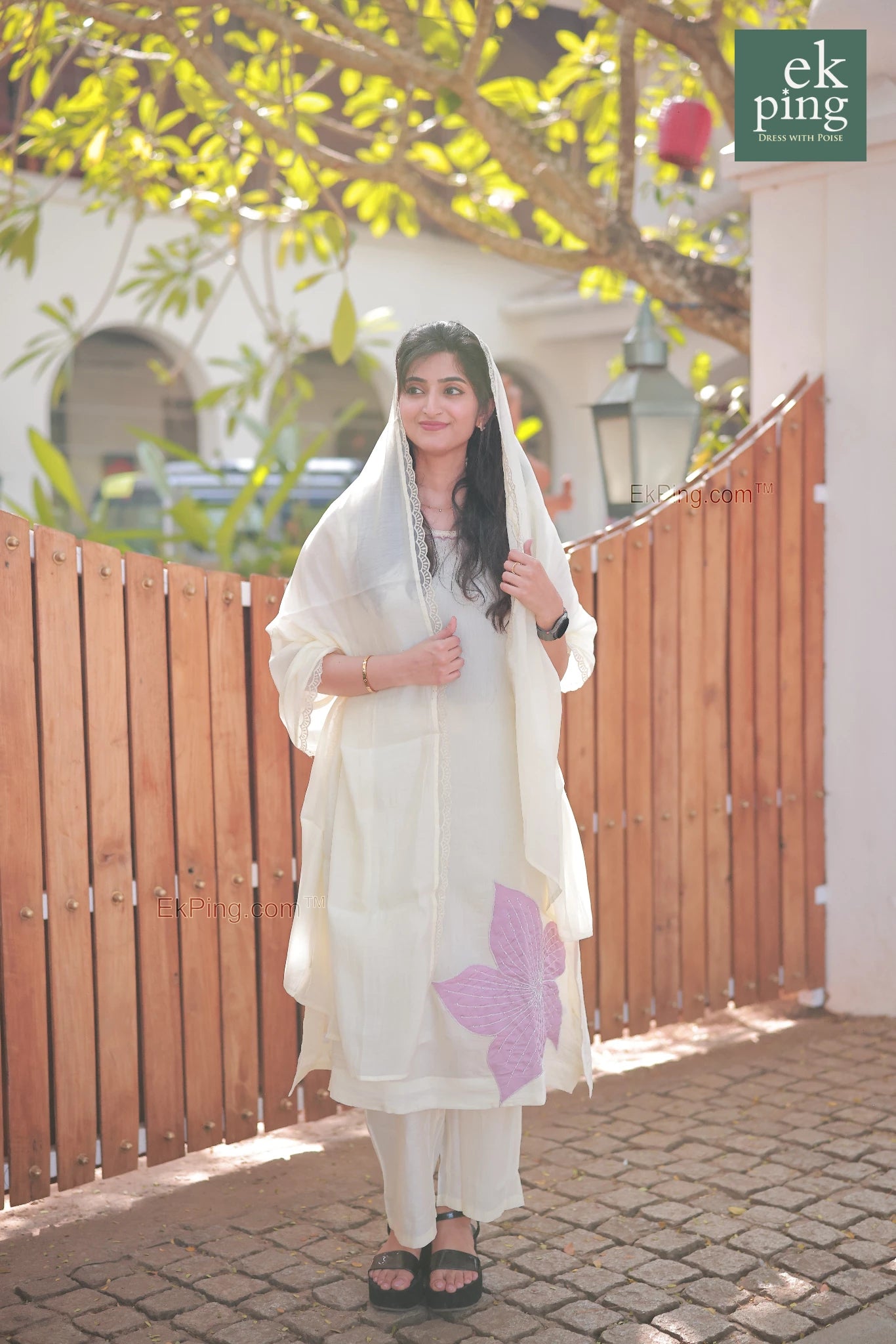 Girl wearing Chanderi Off-White Salwar Set with Dupatta over head in front of a colonial bunglow gate in fort kochi