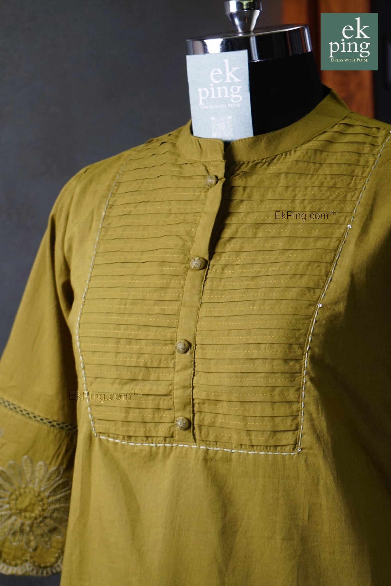 Green office wear co-ord set on a manequin with 'ek ping' branding