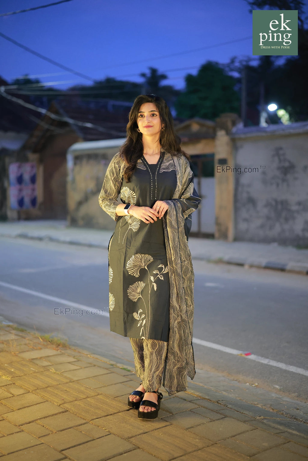Woman in navy black salwar kurti  standing on a street at dusk