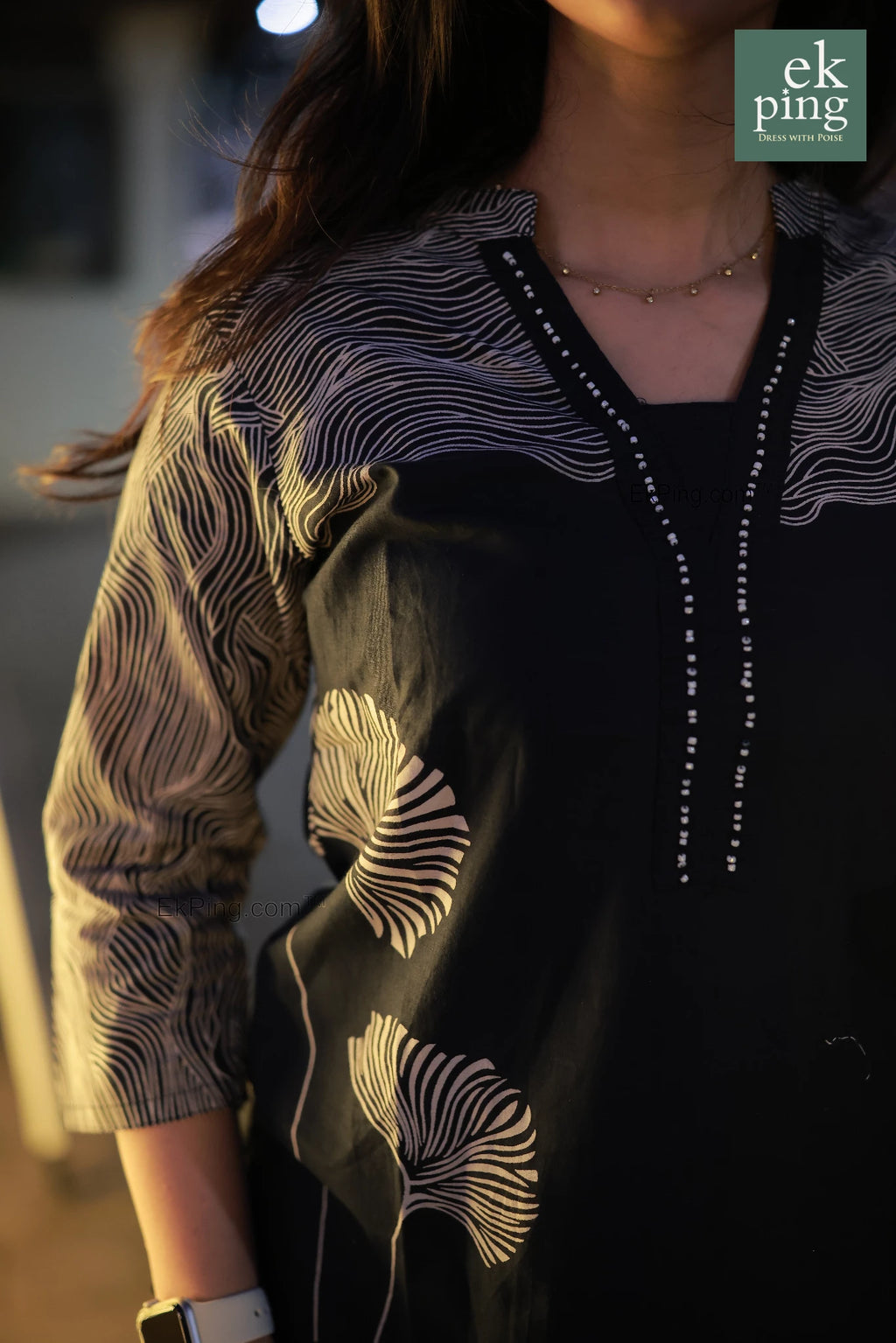 Girl wearing a  navy black salwar kurti patterned outfit with a blurred background