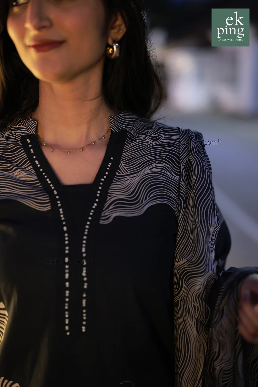 Woman wearing a b navy black salwar kurti with a blurred background