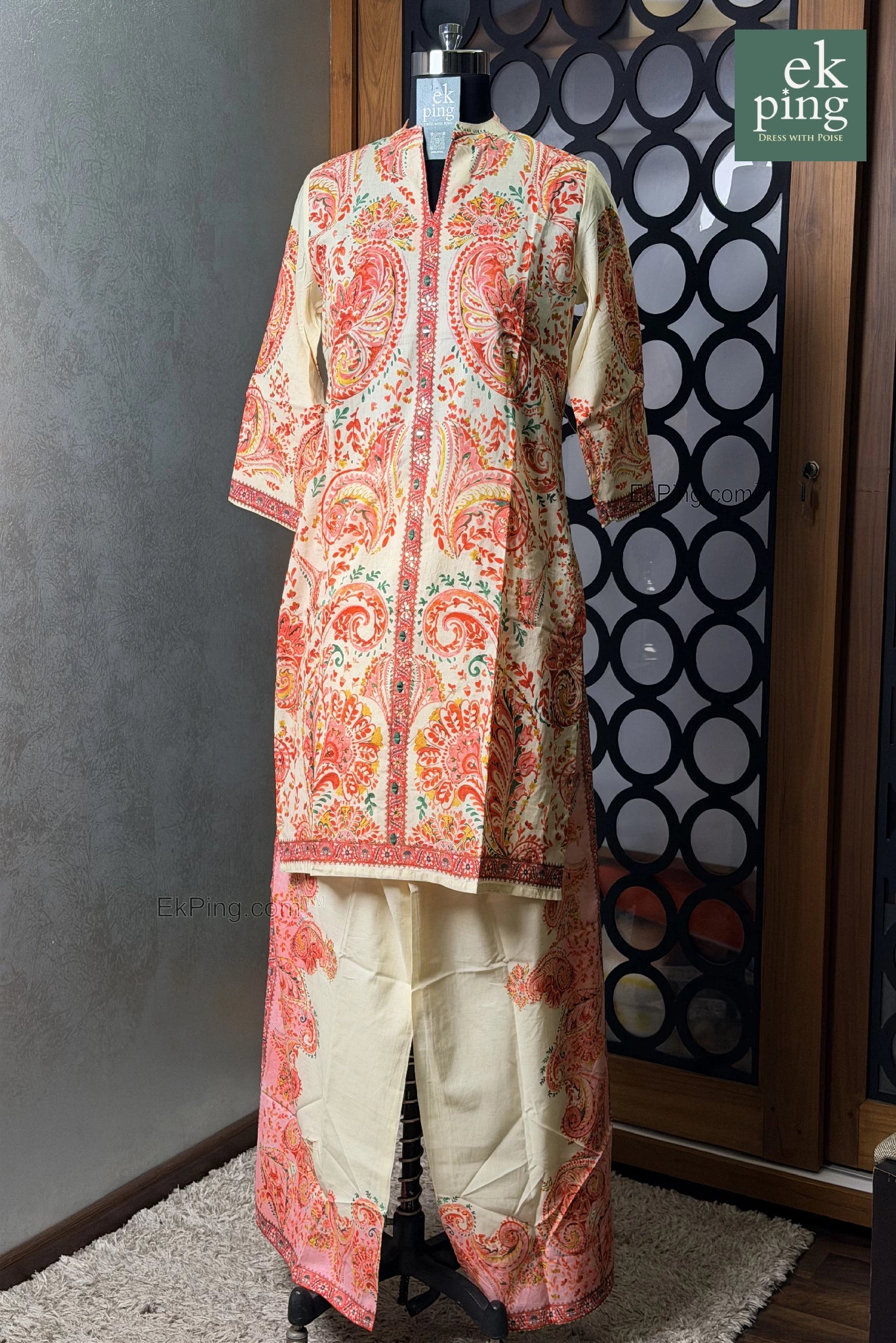 Pink floral co-ord set with palazzo pants on a mannequin against a decorative wall.