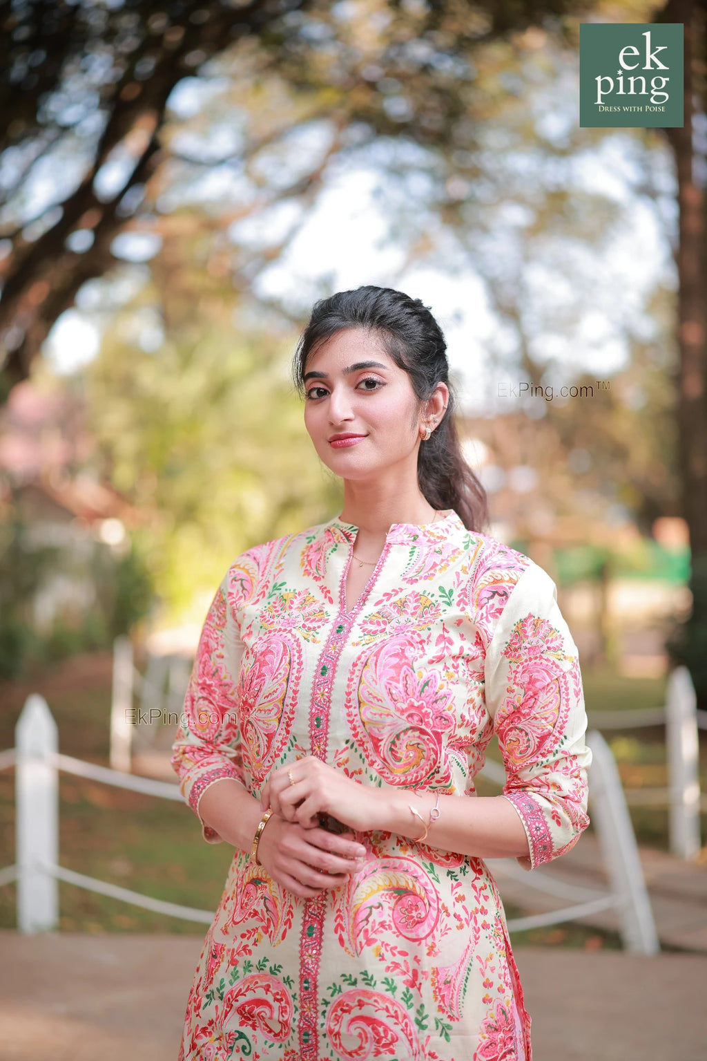 Woman wearing a pink floral co-ord set with palazzo pants with blurred outdoor background
