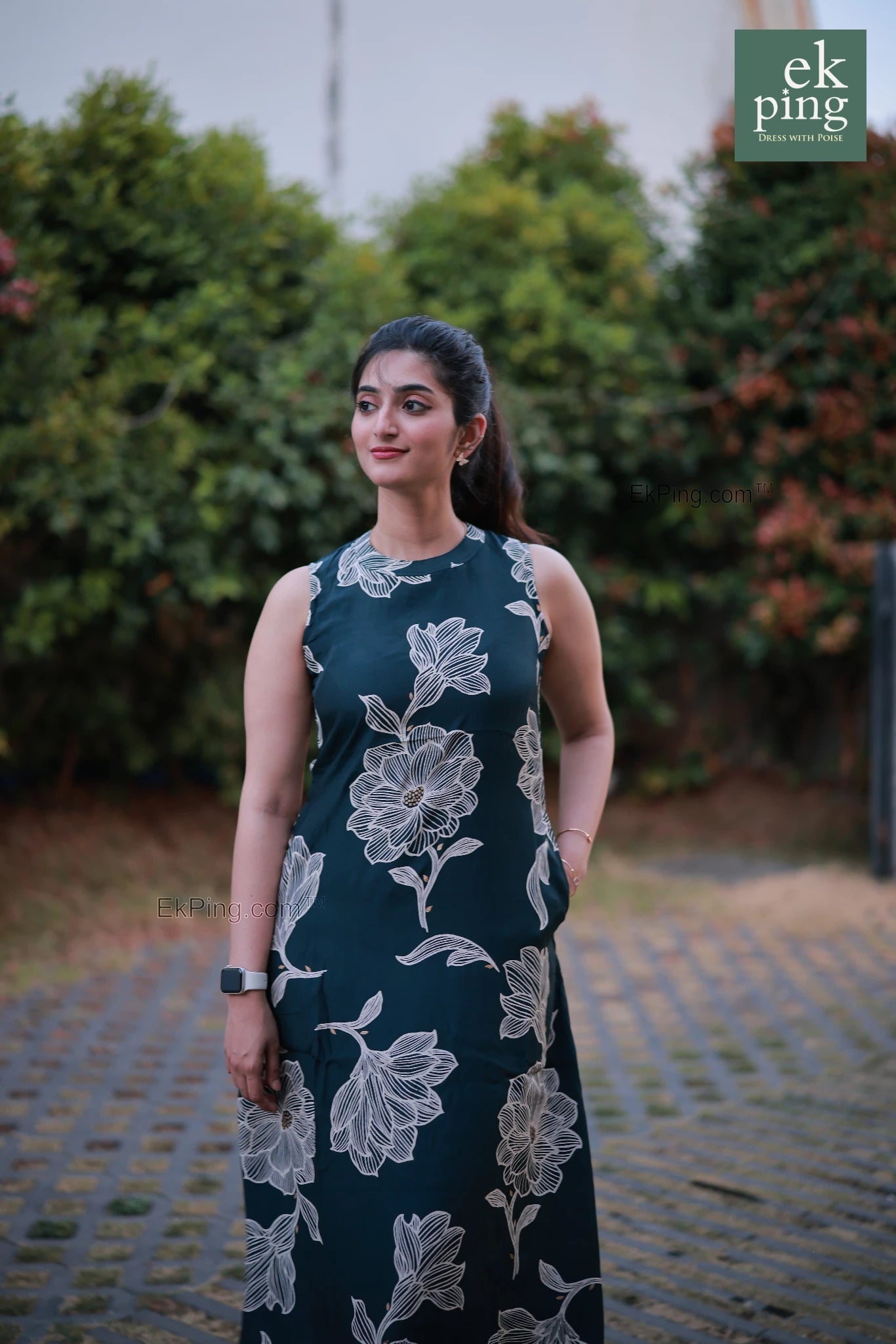 Woman wearing a sleeveless office wear with floral patterns standing outdoors.