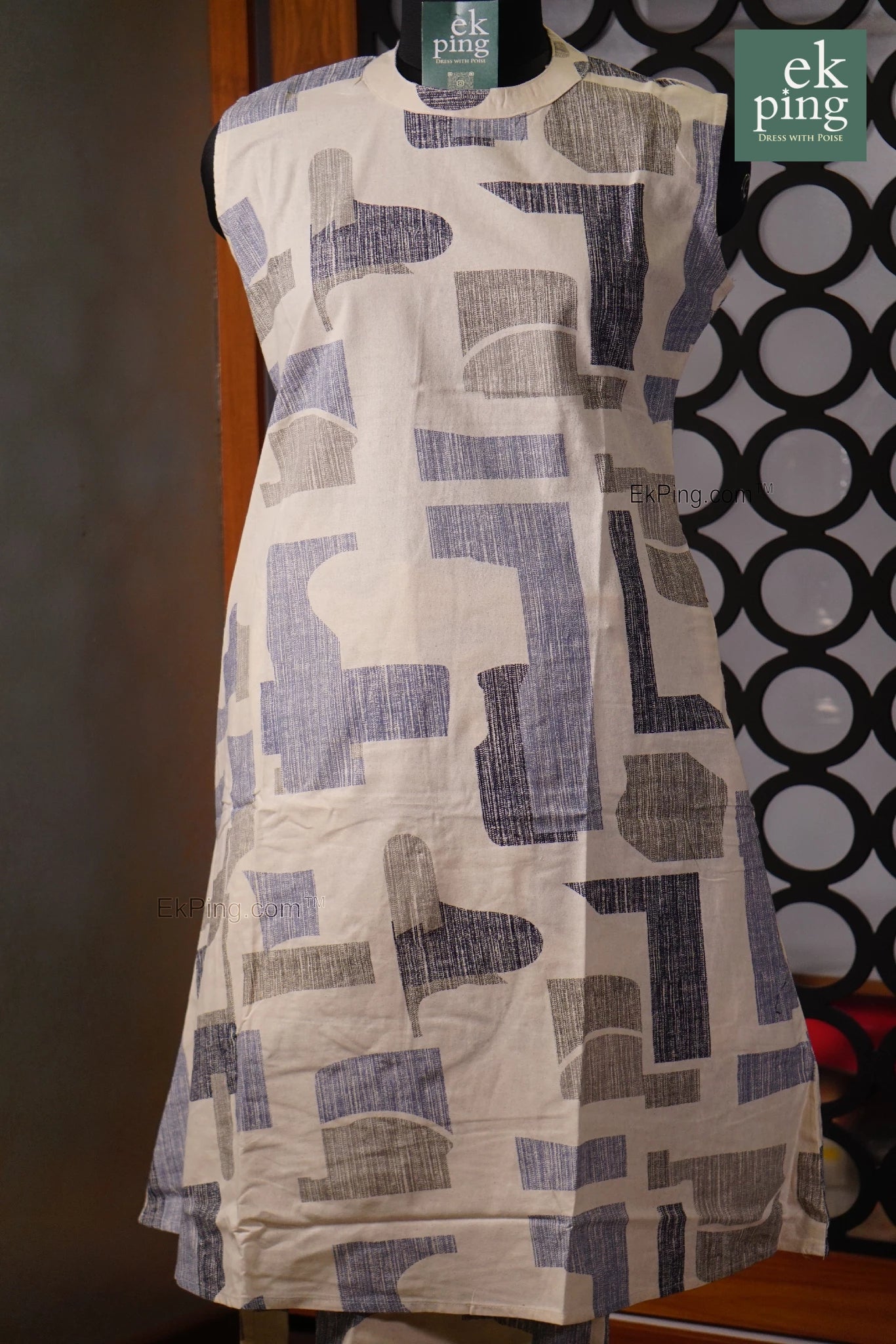 white co-ord set dress with blue geometric pattern on a mannequin against a dark background