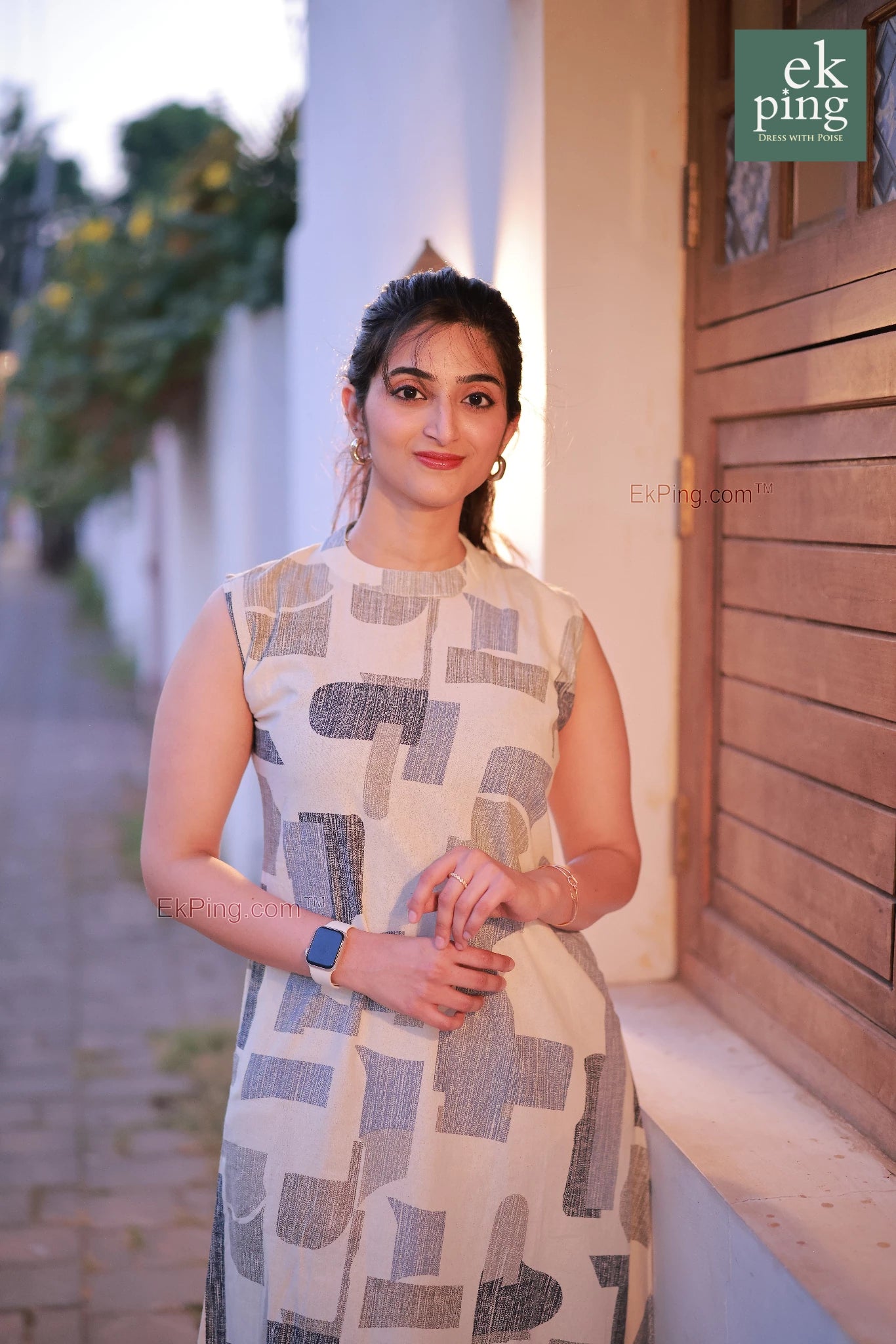 Woman in a white co-ord set dress standing outdoors with a blurred background