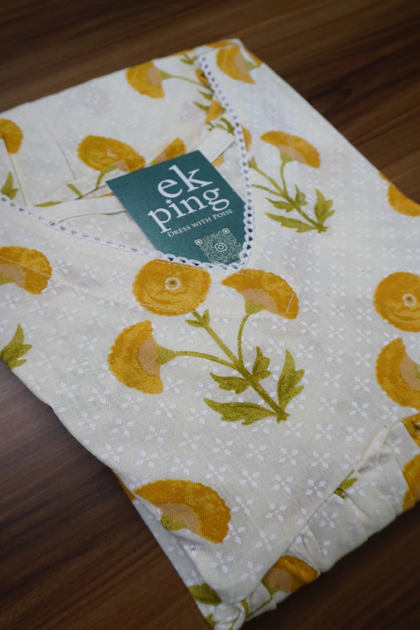 Yellow-office-wear-kurti-top2
Floral-patterned office wear kurti with a EkPing brand tag on a wooden surface