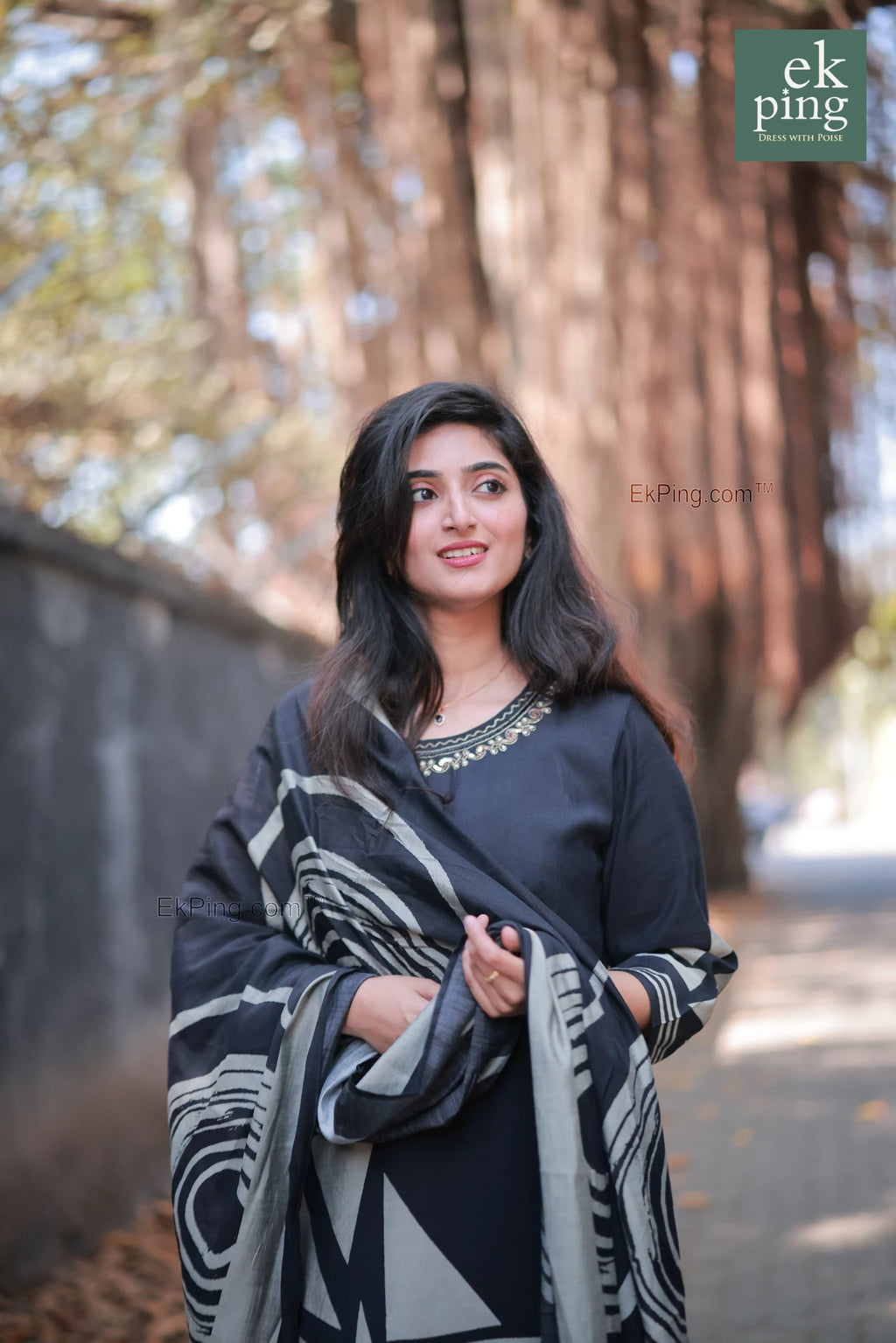 Girl in a black geometric design salwar set with regular pants modelling in front of a cafe