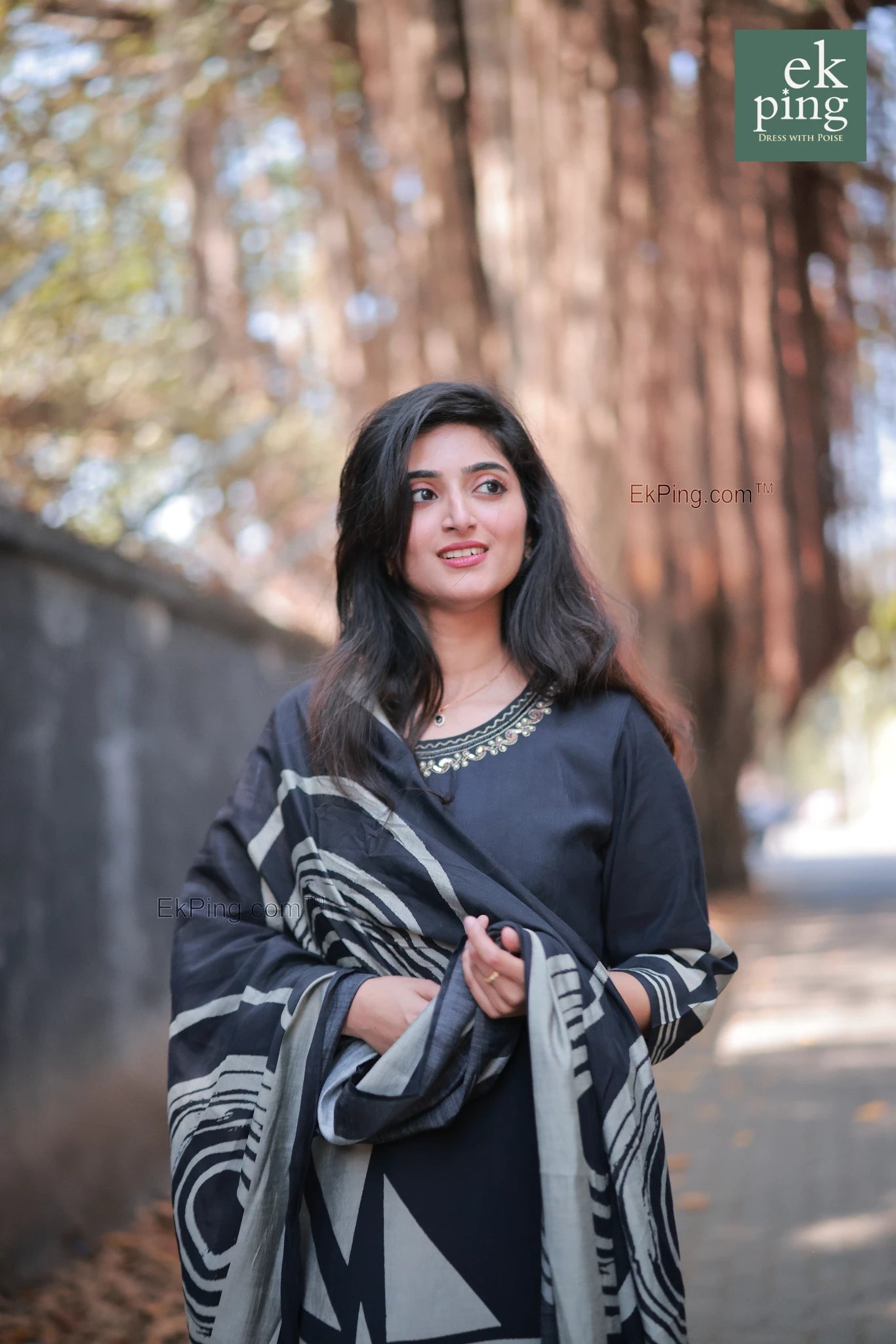 Girl in a black geometric design salwar set with regular pants modelling in front of a cafe